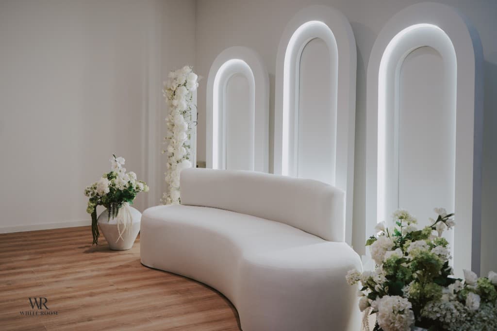 White Room Lounge mit eleganten Bögen und weißer Sofagarnitur